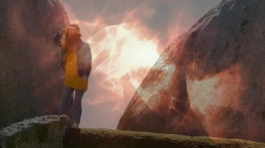 Kaya parçaları arasında ortaya çıkan ve hasır şapka takan bir kadın yolculuk için ışıldayan bir çıkıntının ortasında dengede duruyor. Macera, keşif, engebeli, açık hava, kaçış, kararlılık, manzara