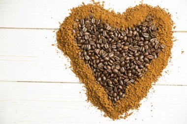 Düz tasarlanmış kalp şeklindeki kahve çekirdekleri, tahtanın üzerinde, kahve sınırında duruyor. Sanatçı, köylü, sıcak, rahat, gurme, minimalist, doğal