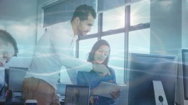 Yönetici, iş projesi incelemesi için tablet seçerek ve monitörde ayrıntıları vurgulayarak rehberlik ediyor. İşbirliği, takım çalışması, danışma, teknoloji, ofis, iletişim, planlama