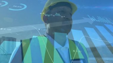 Grafikler göstergeleri güncellerken, görünürdeki mühendis yapı iskeleti üzerinde. Sanayi, teknoloji, analitik, inşaat, sürdürülebilirlik, yenilik, kentsel