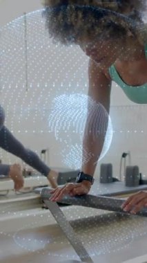 Reformcular üzerinde egzersiz yapan, dijital ağ animasyonu yapan kadınlar spor salonunda üst üste biniyor. Fitness, pilates, egzersiz, teknoloji, yenilik, egzersiz