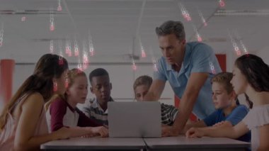 Öğrenciler eğilirken ve çift haneli rakamlar sürüklenirken öğretmen dizüstü bilgisayarı işaret ederek kodlama dersine başlıyor. Eğitim, takım çalışması, dijital, yenilik, sınıf, işbirliği, fütüristik