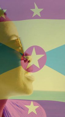 Kumsalda gülümseyen birinin güneş gözlüğü takması üzerine Grenada bayrağı animasyonu. Ulusal bayrak, tatil, tropikal, yaz, neşe, yaşam tarzı
