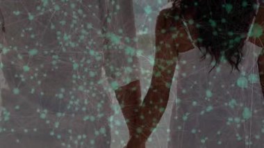 Çift ellerini açıyor ve kıyı şeridine ulaşmak için yürürken dijital ağ onları birbirine bağlıyor. Romantik, bağlantı, sükunet, teknoloji, dinginlik, birlik, gelecekçilik