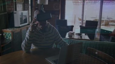 Üst düzey adam VR UI 'ye girip yüzen veri noktalarını keşfeden bilgisayar ekranına bakıyor. Son sınıf, teknoloji, dalış, yenilik, rahatlama, konforlu, çağdaş