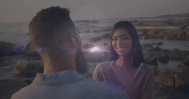 Gün batımında kıyıda kadının karşısında duran bir adam, seyahat pazarında ışıldayan bir merceğe dönüşüyor. Romantizm, günbatımı, manzara, bağlantı, dinginlik, duygu, doğal