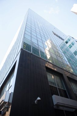 Low angle view of glass building against sky on sunny day