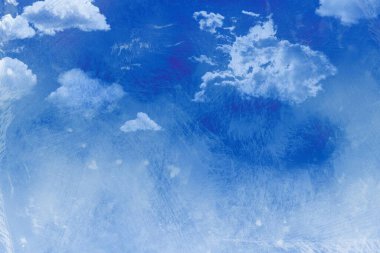 Koyu mavi gökyüzü tuval boyunca yayılıyor, kabarık bulutları ve sıkıntılı resmedilmiş dokuları gösteriyor. Soyut, atmosferik, sanatsal, desenli, karamsar, manzaralı, canlı