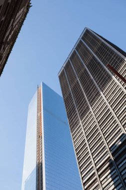 Düz dizayn, cam gökdelenin, taş cephe ve şebeke kulesinin yanında turuncu asansörle büyüdüğünü gösteriyor. Modern, gökdelen, mimari, şehir, inşaat, şehir manzarası, minimalist