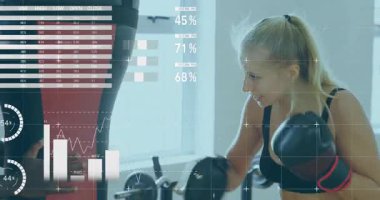 Spor salonunda eldiven takan atletlerin kum torbasını güvence altına aldıktan sonra, koçun yol göstermesi ve güncelleme ölçümlerini üst üste koyması. Fitness, atletizm, performans, teknoloji, eğitim, güç, analiz