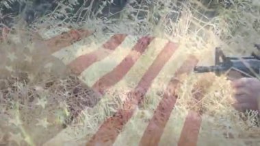 Askeri asker çimleri yararak ilerliyor. Amerikan bayrağı çekiliyor. Tüfek menzilini ayarlıyor ve hedefe nişan alıyor. Vatanseverlik, kamuflaj, disiplin, ordu, hassasiyet, taktik, dayanıklılık