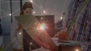 Ofiste çalışan analistin yanında yazan adam ağ kaplamasını başlatıyor ve kulaklık takıyor. İşbirliği, teknoloji, dijital, yenilik, takım çalışması, arayüz, işyeri