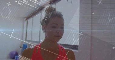 Fitness stüdyosunda duran bir kadın vücut geliştirme ölçümlerini canlı olarak göstererek yüksek çözünürlükteki dalgalanmaları etkinleştiriyor. Fitness, teknoloji, analiz, sağlık, yenilik, motivasyon, arayüz