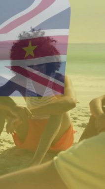 Niue bayrağıyla plajda dinlenen bir grup arkadaş animasyon sergiliyor. Seyahat, tatil, tropikal, rahatlama, rahatlama, eğlence