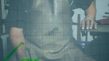 Önlük takan metal işçisi kerpeteni döndürmeden önce ızgara takip çizgisi grafiklerini gösteriyor. Sanayi, zanaat, teknoloji, analitik, kesinlik, atölye, mühendislik