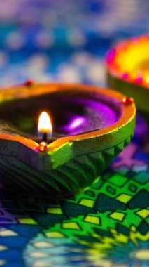 Mor ve yeşil desenli yüzeyde parlayan diwali mumlarının videosu. diwali, ışık festivali, yeni yıl, gelenek ve kutlama konsepti.