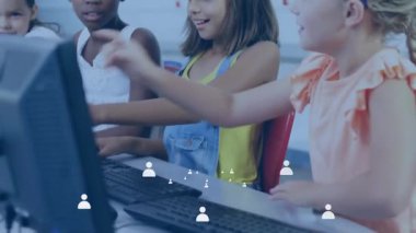 Bilgisayar ekranını işaret eden ve klavyeye dokunan öğrenci kızlar eğitim laboratuarında heyecanı paylaşıyorlar. Çocuklar, eğitim, takım çalışması, teknoloji, işbirliği, öğrenme, gençlik