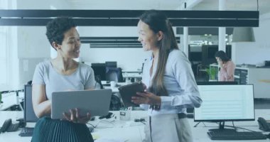 Two women collaborating in tech, turbine icon fading, code snippets animating during visualization. Collaboration, teamwork, digital, innovation, modern, professional, analytics