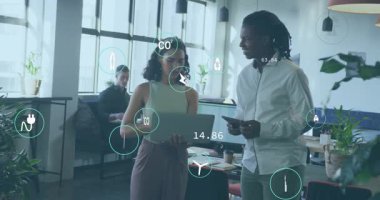 Laptop açılıyor, kadın ve erkek ofiste sürdürülebilirlik verilerini analiz ediyor, canlandırılmış simgeler güncelleniyor. İşbirliği, yenilik, analitik, eko verimlilik, dijital, takım çalışması, modern