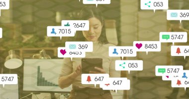 Tablet tutuyor, beyaz bluz giyen işçi ofiste bildirimleri kontrol ediyor, bar tablosu ekranıyla birlikte. Profesyonel, modern, canlı, bağlantı, teknoloji, üretkenlik, verimlilik