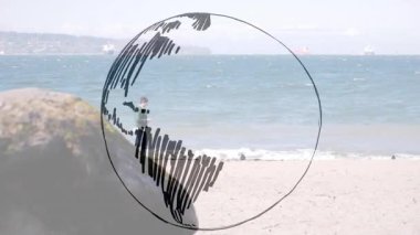 Kumlu sahil şeridinde insan yürürken el çizimi çemberi zayıflıyor. Deniz kenarı, çizim, keşif, açık hava, minimalist, iletişim, çevre