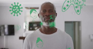 Olgun bir adam evde durmuş, yeşil sağlık simgeleriyle ona gülen bir yüze rehberlik ediyor. Sağlık, sağlık, sağlık, güvenlik, güven, hijyen, temizlik