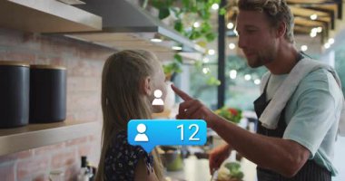 Babası sosyal medya gelişimi için yemek pişiriyor. Kızının burnunu tıkırdatarak uçan ikon sürücüsü sayılıyor. Aile, mutfak, eğlence, kaynaşma, sosyal medya, etkileşim, modern