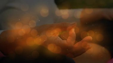 Kamera, yoga sırasında altın küreler kayarken yaşlı kadının Mudra 'ya dokunduğunu gösteriyor. Meditasyon, farkındalık, sükunet, dinginlik, manevi, sağlık, ahenk.