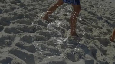 Çerçeveye girer girmez, arkadaşlar dönen ağ küresinin altından kumu geçerek bağlantıyı gösteriyorlar. Plaj, arkadaşlık, bağlantı, dijital, modern, boş zaman, açık hava