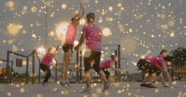 Spor salonlarında altı kadın pembe gömlekli ve siyah tozluklu, metal parmaklıklı egzersiz yapıyor. Atletizm, yoldaşlık, canlılık, güç, açık hava, takım çalışması, aktif giysi