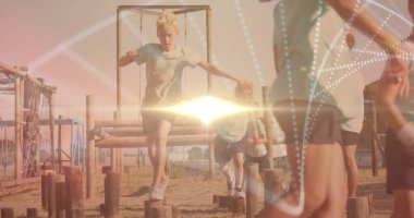 Çocuklar tahta direkler üzerinde dengede dururken engelli parkurdan atlayan bir adam. Macera, fitness, yaz, takım çalışması, açık hava, aktivite, spor