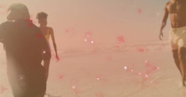 Yürüyen bir aile kıyı şeridinde şort, tek parça şort ve şort giyiyor. Su ve pembe ışıltılı. Aile, sahil, sahil, sahil, tatil, dinlenme, sükunet.