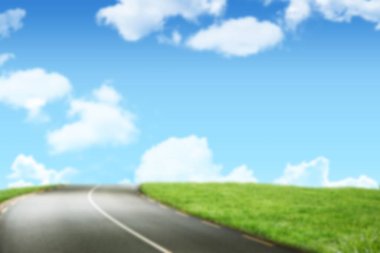 Gökyüzüne karşı çimenli alanda virajlı yol