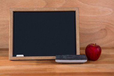 Tahtada toz bezi ve elma var.