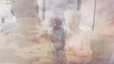 Bulut örtüsü çekiliyor, tablet simgeleri görünürken kel kolaylaştırıcı sağlık destek grubuna rehberlik ediyor. Liderlik, toplum, iletişim, refah, yaşlılık, çeşitlilik, akıl hocalığı