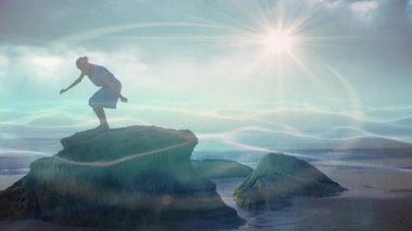 Kıyı kayalarının kenarında duran bir kadın, ışık desenleri ile sağIık için meditasyona başlıyor. Manzaralı, düşünceli, sakin, doğal, sakin, yansıtıcı, farkındalık.