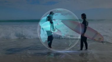 Sahil şeridinde duran sörfçüler ışık küresi değiş tokuşu yapıyor ve dijital dünyayı teknolojik demo için aktifleştiriyor. Macera, dijital, yenilik, takım çalışması, canlı, açık hava, dinamik