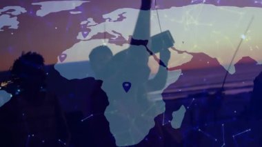 LED ipleri tutan iki dansçı kıtaları birbirine bağlayan düğümlerle dijital haritayı etkinleştiriyor. Siluet, teknoloji, bağlantı, açık hava, hareket, yenilik, canlı