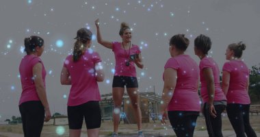 Önde gelen fitness eğitmeni tozlu sahada öğrencileri saatli düdükle yönlendiriyor. Eğitim, takım çalışması, açık hava, canlı, motivasyon, atletik, dijital