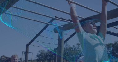 Açık yeşil tişört giyen ve eldivenli sallanan çocuk parkta metal maymun parmaklıklarına tırmanıyor, fotokopi uzayı. Oyun alanı, çocuklar, açık hava, etkinlik, eğlence, coşku, denetim