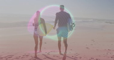 Sahilde sörf tahtası ve ayak izleriyle dalgıç kıyafeti ve şort giyen iki sörfçü. Sahil, macera, eğlence, spor, açık hava, arkadaşlık, coşku