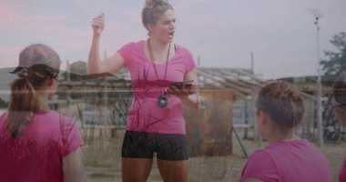 Spor koçu, çim tarlasında eğitimcileri tahta engellerle, tablet ve kronometre ile eğitiyor. Açık hava, eğitim, motivasyon, takım çalışması, sağlık, aktif, spor