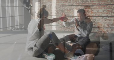 Stajyer antrenör, boks ringinde diz çökmüş antrenörlere yumruk atıyor. Kırmızı sargı bezleriyle spor çantasıyla. Sporcu, koç, güç, kararlılık, fitness, antrenman, spor