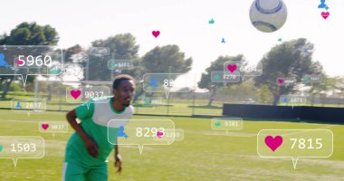 Yeşil-beyaz takım giyen koşucu çimen sahada top kovalıyor, yüzen sosyal simgeleri gösteriyor. Sporcular, takım çalışması, sportmenlik, açık hava, dinamik, enerjik, rekabetçi