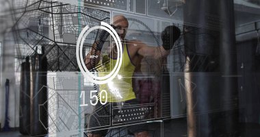 Sarı askılı boksör ve spor salonunda siyah eldivenler, kum torbası, dijital arayüz. Fitness, antrenman, teknoloji, spor, güç, atletizm, modern