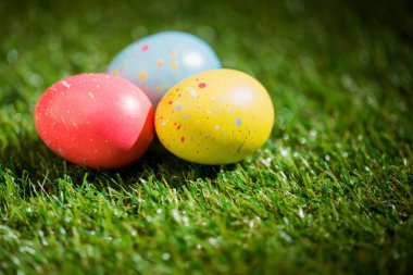 Bahçedeki çimlerin üzerinde renkli Paskalya yumurtaları