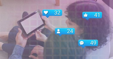 Oturma odasında sosyal medya simgeleriyle boş ekran tablet kullanan iki arkadaş etkileşimi. Teknoloji, iletişim, gündelik, modern, yaşam tarzı, bağlantı, dijital