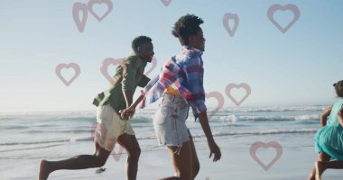 Kumsalda ıslak kumlu sahil şeridinde el ele tutuşan ve yumuşak okyanus dalgaları akan bir aile. Kıyı, eğlence, dinginlik, birliktelik, macera, canlı, doğal