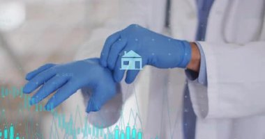 Kıdemli doktor eldiven kutusunu tutuyor, mavi eldiven takıyor ve sınav için ev simgesini ele veriyor. Tıbbi, sağlık, profesyonel, klinik, tanı, güvenlik, muayene