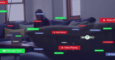 Modern oturma odasında dizüstü bilgisayara doğru eğilen olgun bir kadın yazıyor. Teknoloji, iletişim, dijital, iç mekan, çağdaş, boş zaman, bağlantı